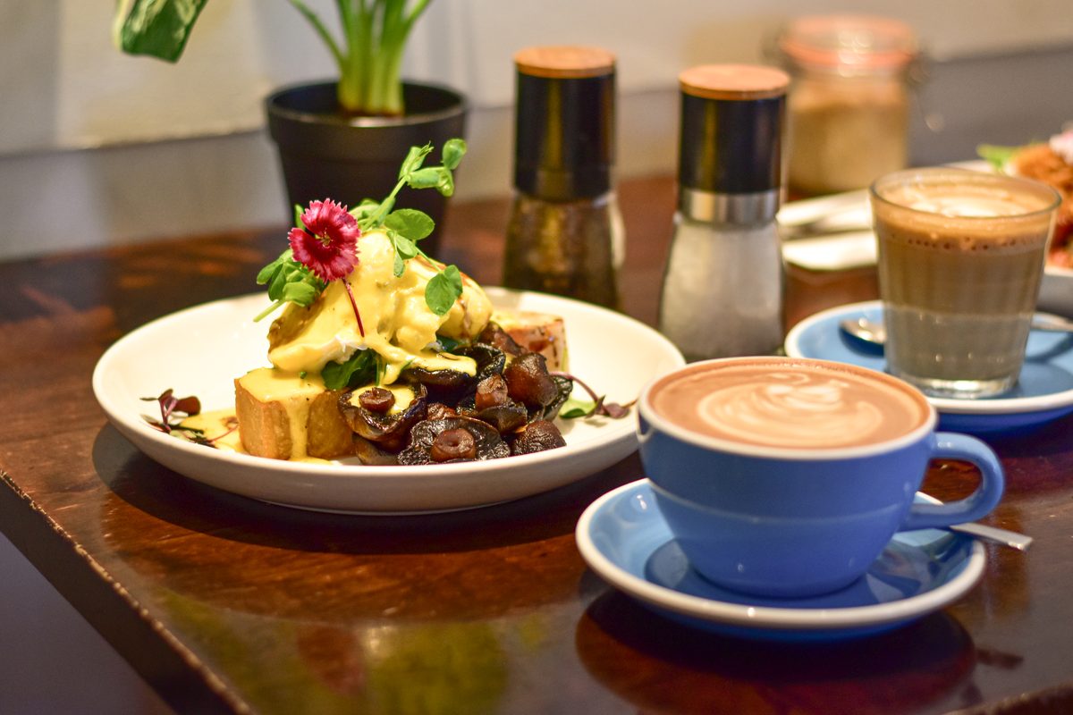 Eggs benedict brunch plate with a flat white at Mission Bay Cafe